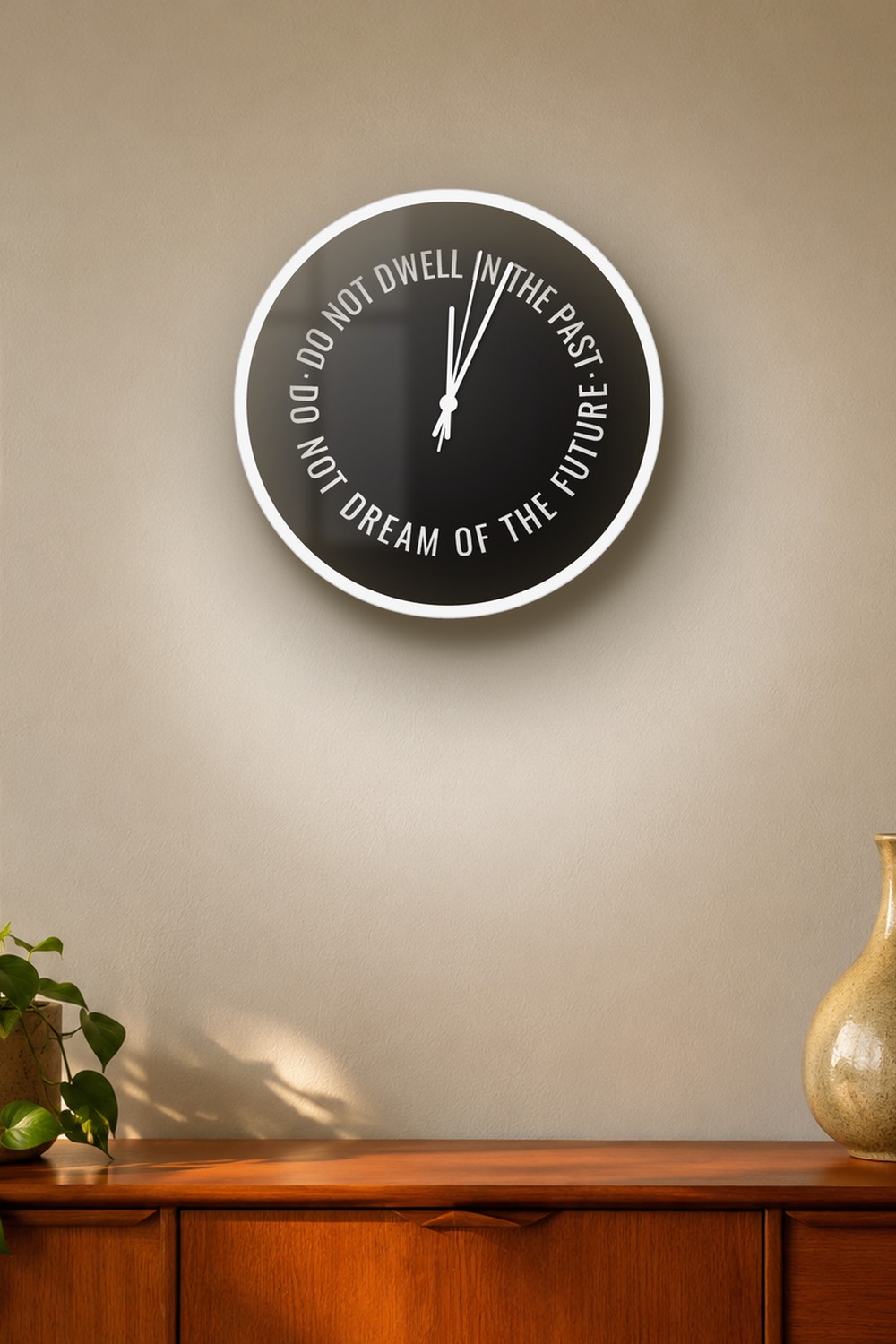 "do not dwell in the past do not dream of the future" wall clock in near-black stone and white, on a wall