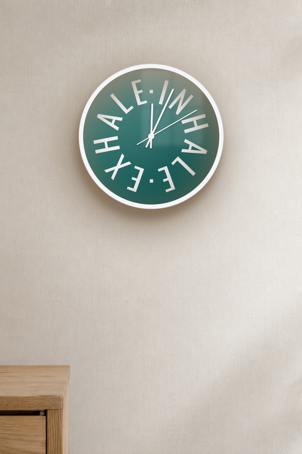 "inhale exhale" wall clock in dark teal and white, on a wall