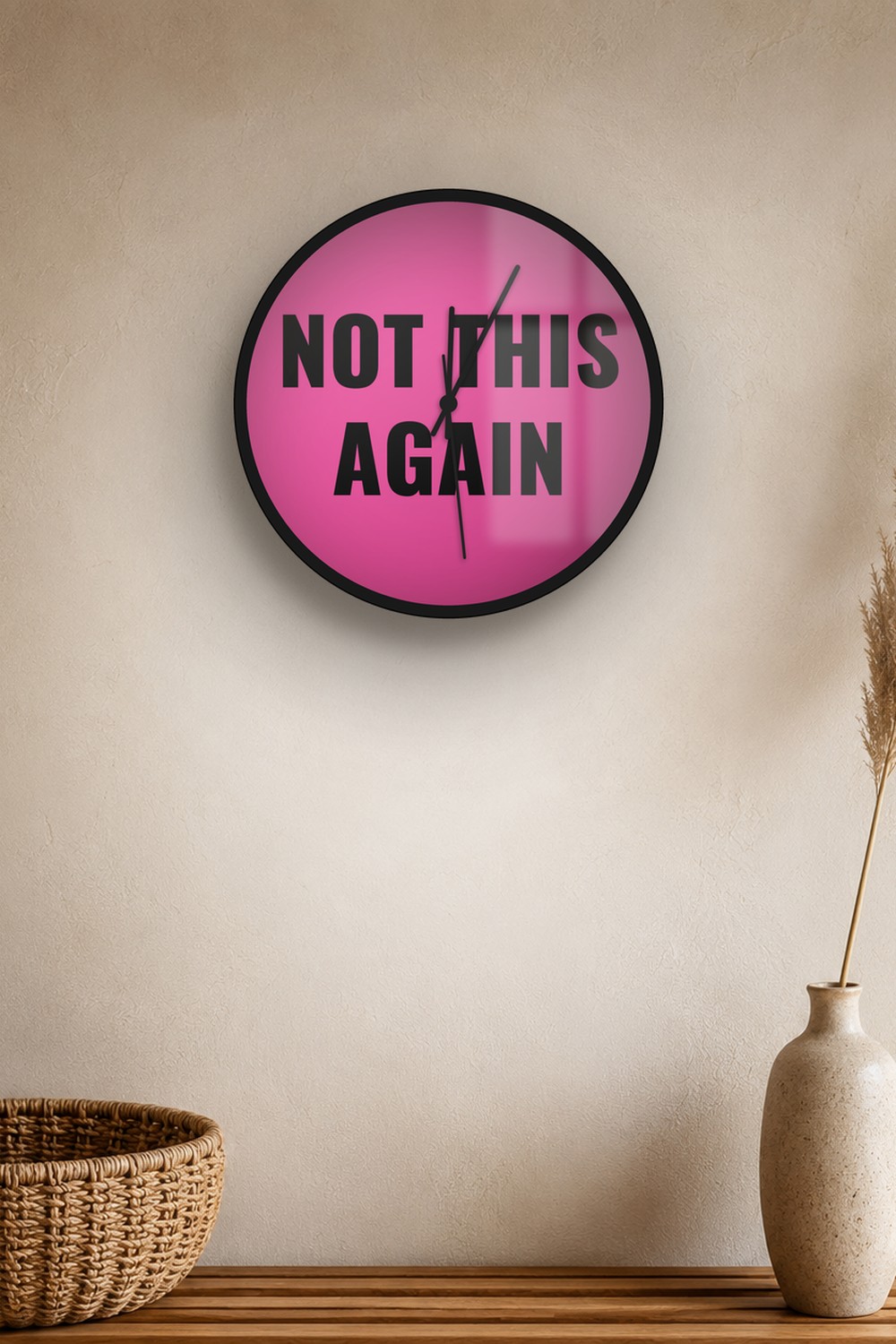 "Not this again" wall clock in pink and black, on a wall